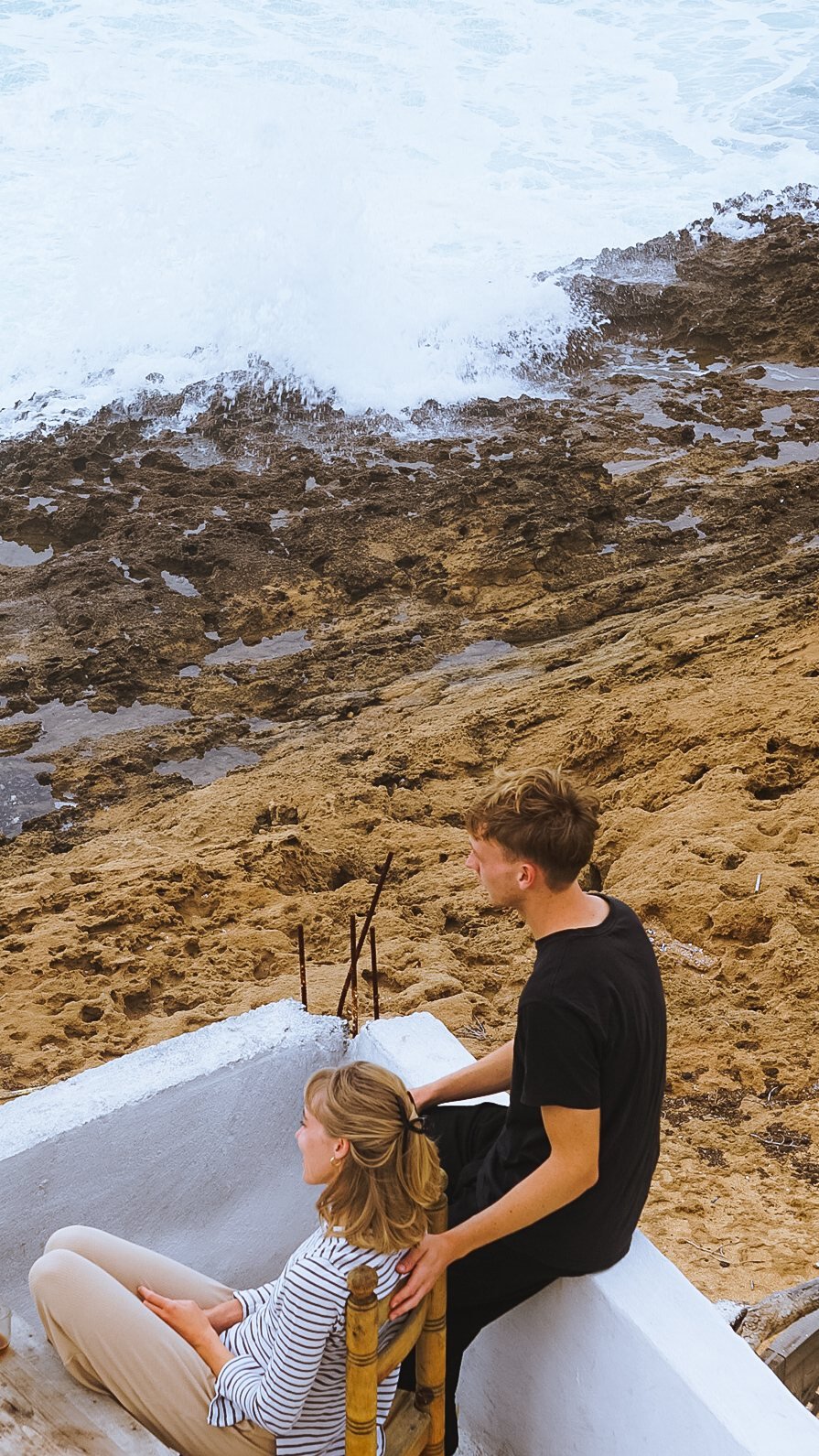 Couple watching the Atlantic waves crash below the Ajarif terrace