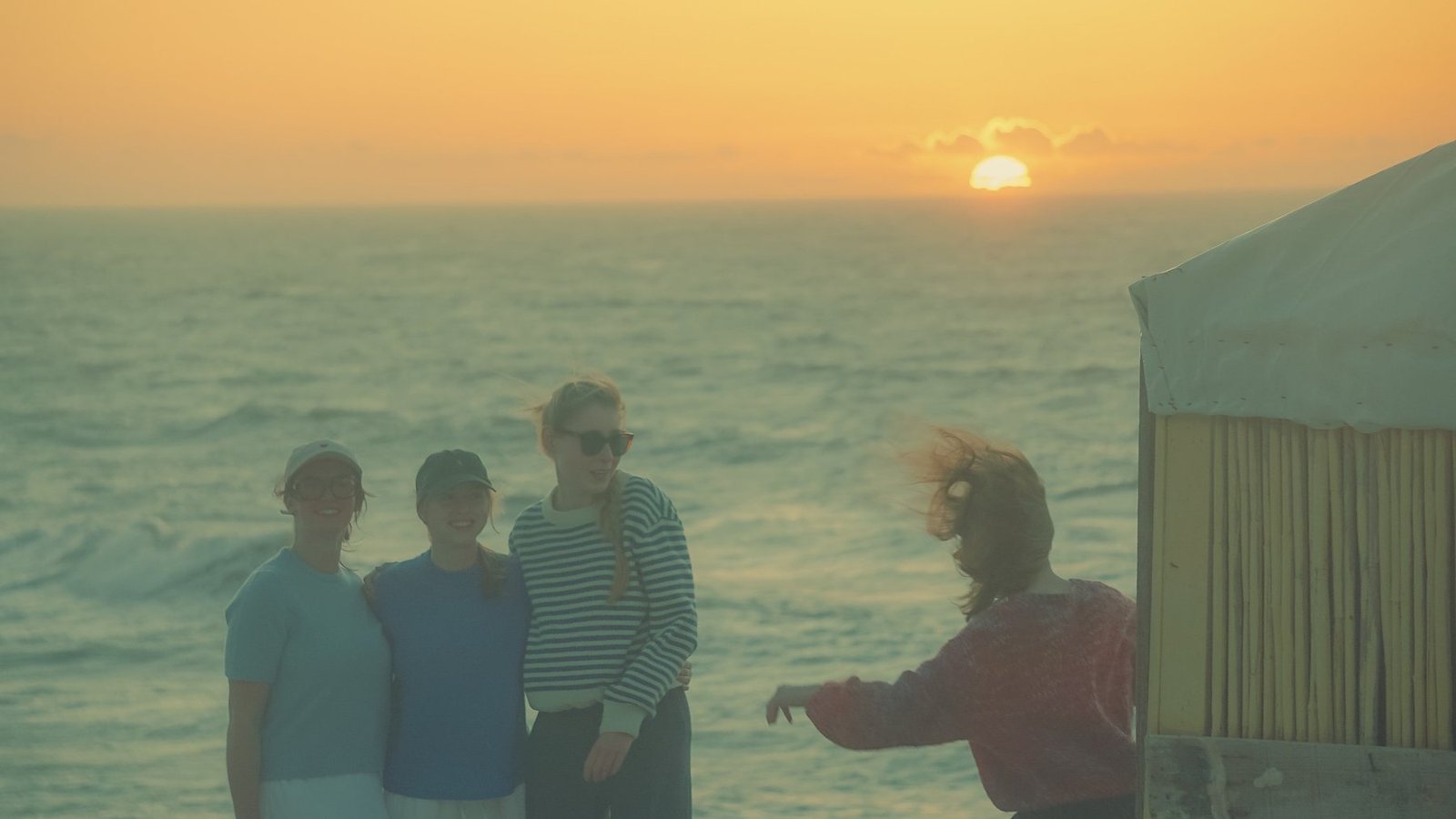Friends laughing at sunset by the ocean at Ajarif, Timlalin