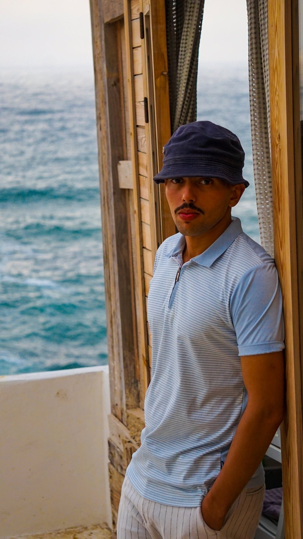 Guest at the wooden cabin door with the ocean behind, Ajarif