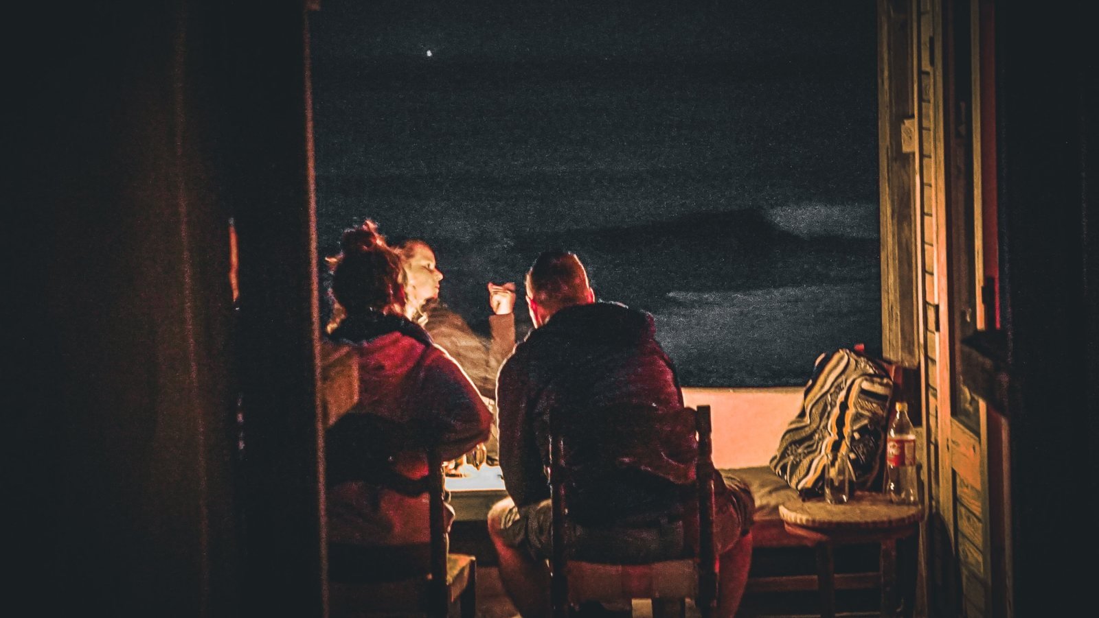 Guests around a night fire at Ajarif Fisherman's Cabin