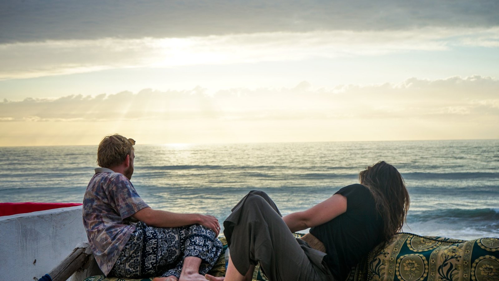 Guests enjoying sunset on the Ajarif cabin terrace above the ocean in Timlalin