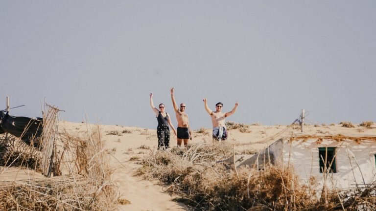 Happy guests waving from the top of a sand dune in Timlalin